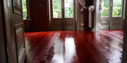 Ossebloed rood geverfde houten vloer in de oude pastorie van Winsum in Groningen