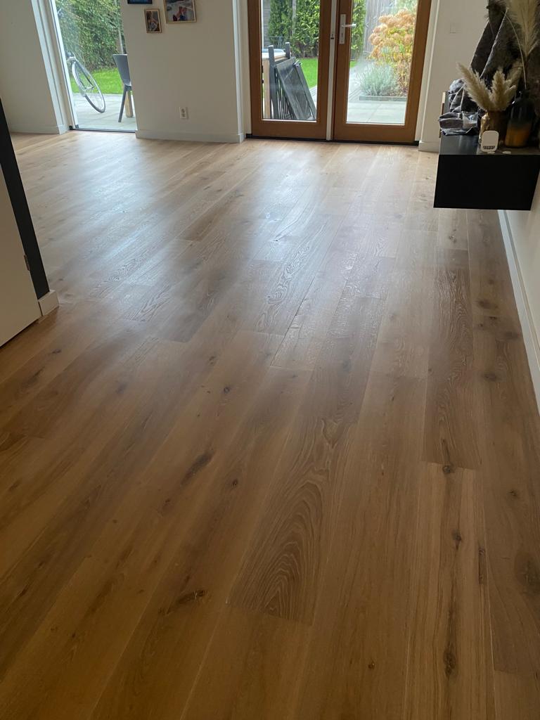 De eiken vloerplanken zijn in de lengte van de kamer gelegd.
