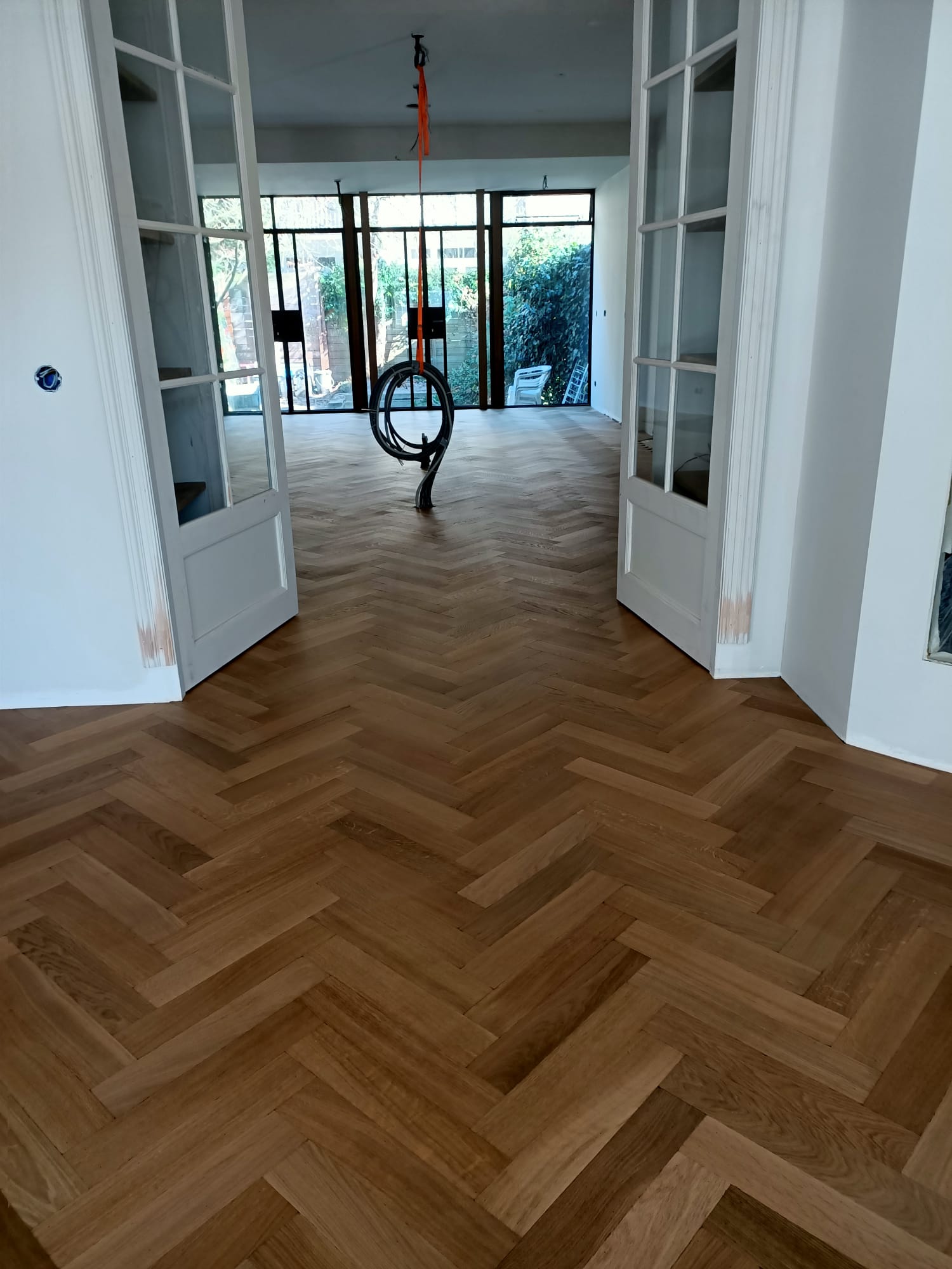 Doorkijkje in de gehele woonkamer. De keuken wordt nog geplaatst met een eiland. De visgraat is net gelakt dus glimt nog maar dat verdwijnt.