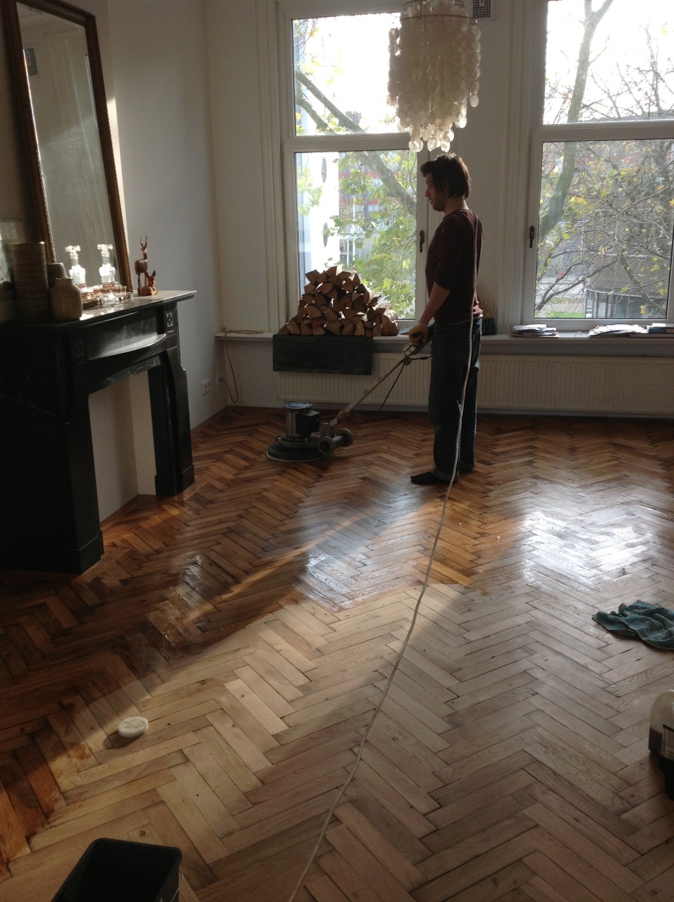 De antiek houten visgraat vloer wordt na het leggen geolied.