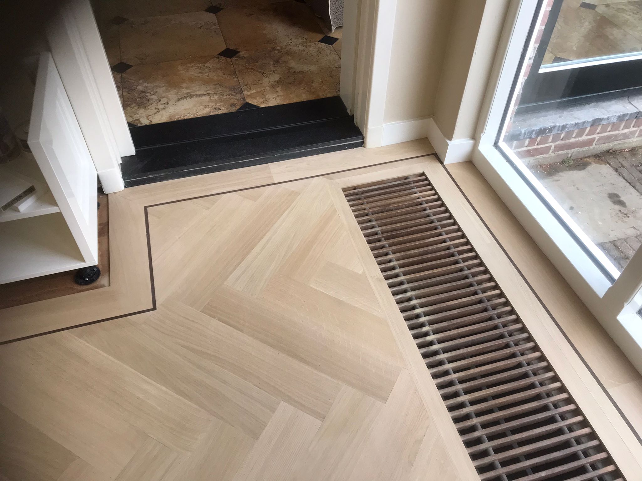 Prachtige klassiek eiken visgraat vloer met perfecte convectorput afwerking in Rotterdam door Holtz Houten Vloeren gelegd.