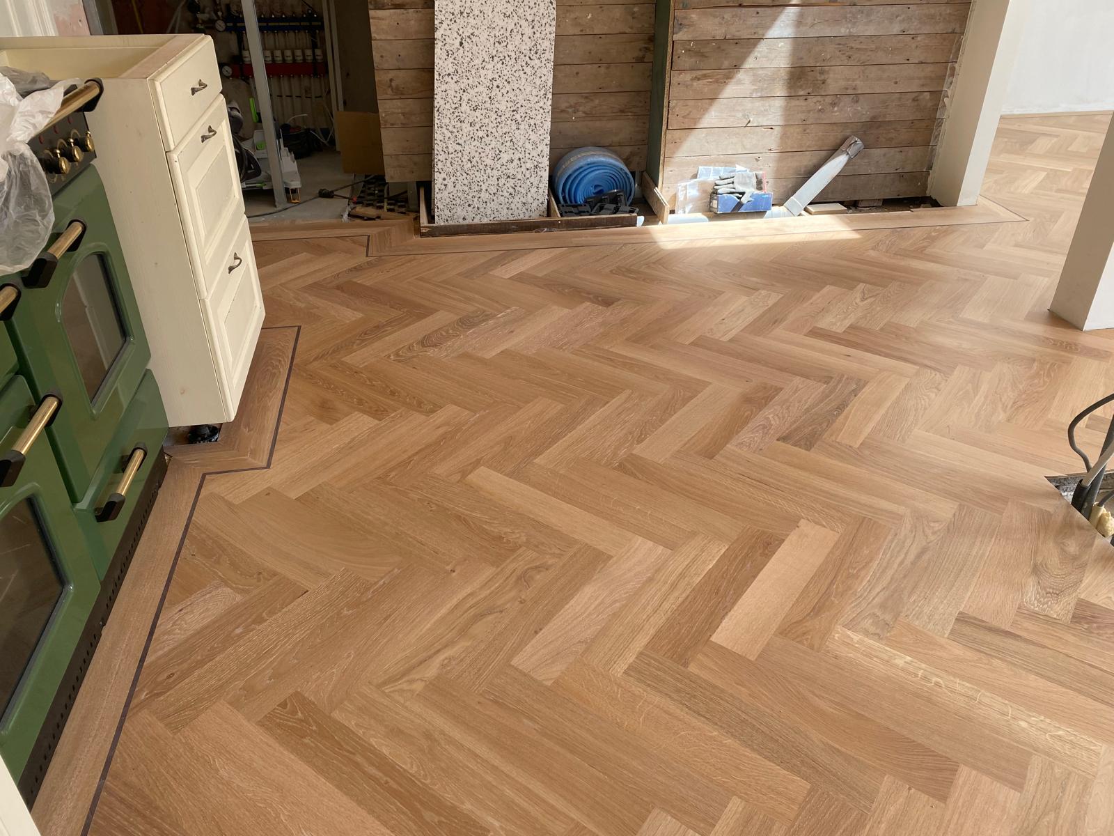 Voor de keuken langs is de visgraat vloer ook gelegd. De eiken stroken zijn sterk genoeg om het gebruik te weerstaan.